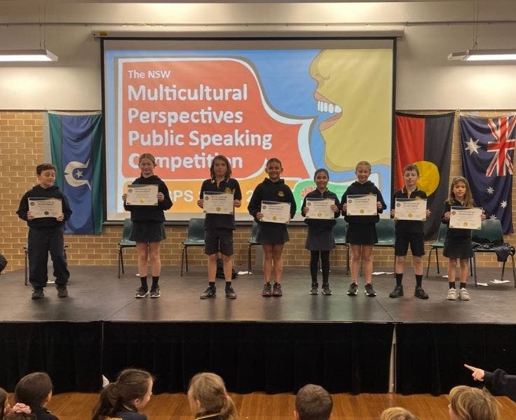 Photo of our eight Multicultural Public Speaking competition finalists across Stage 2 and 3.