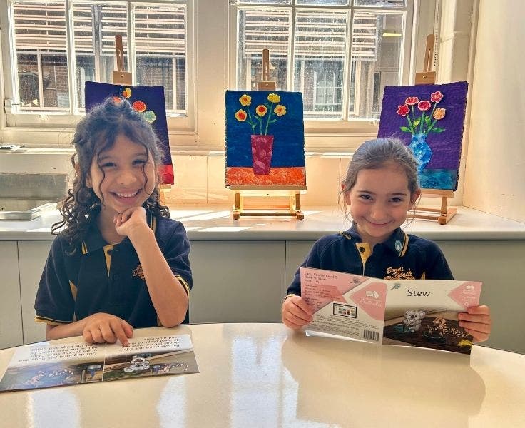 Two students reading decodable readers.