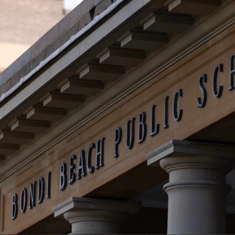 Photo of the schools main sandstone entrance with the school name.