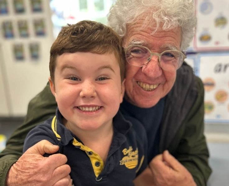 Photo of a kinder student with his grandfather.
